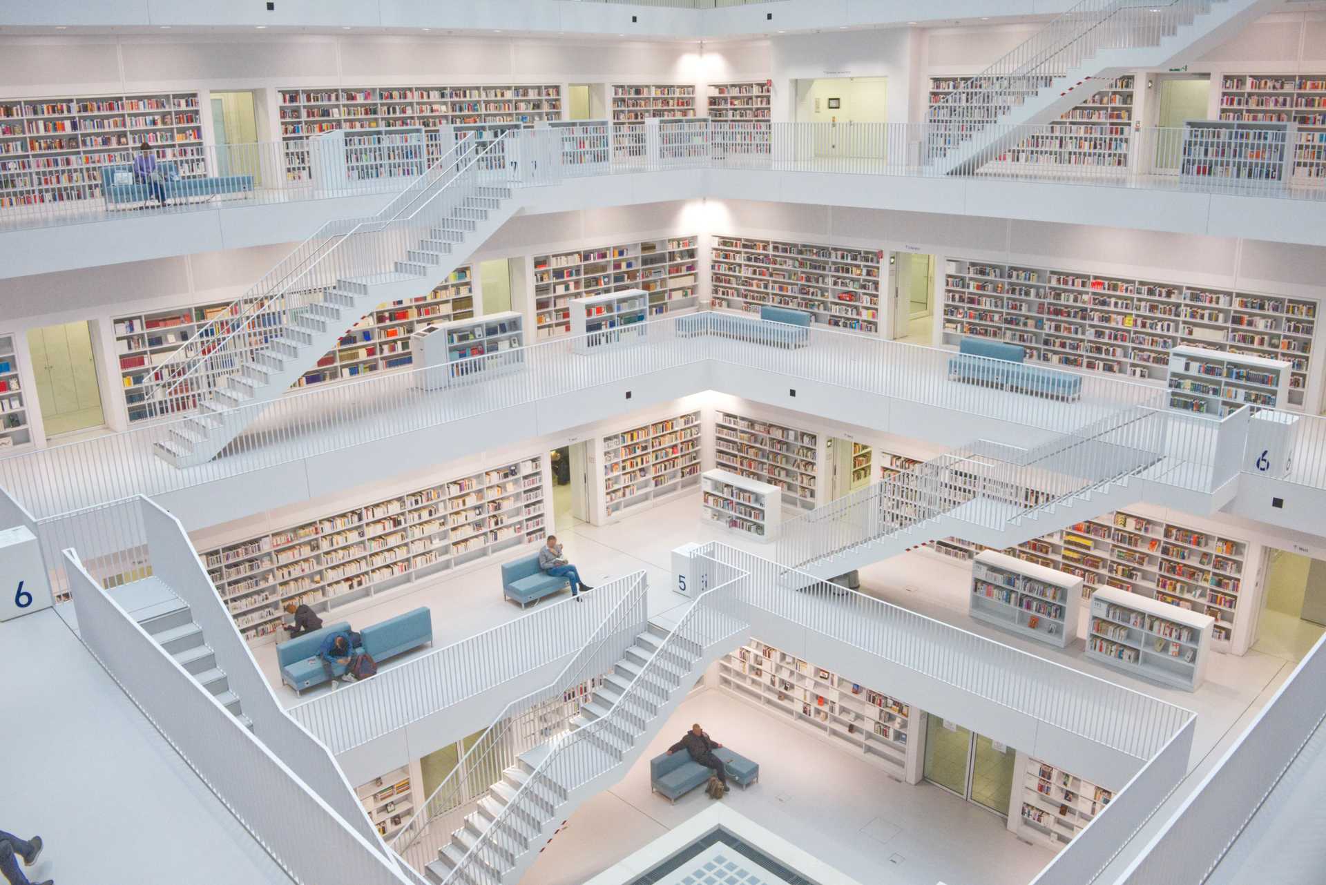 A massive library of books with stairs all over. There are nice sitting areas to read on.