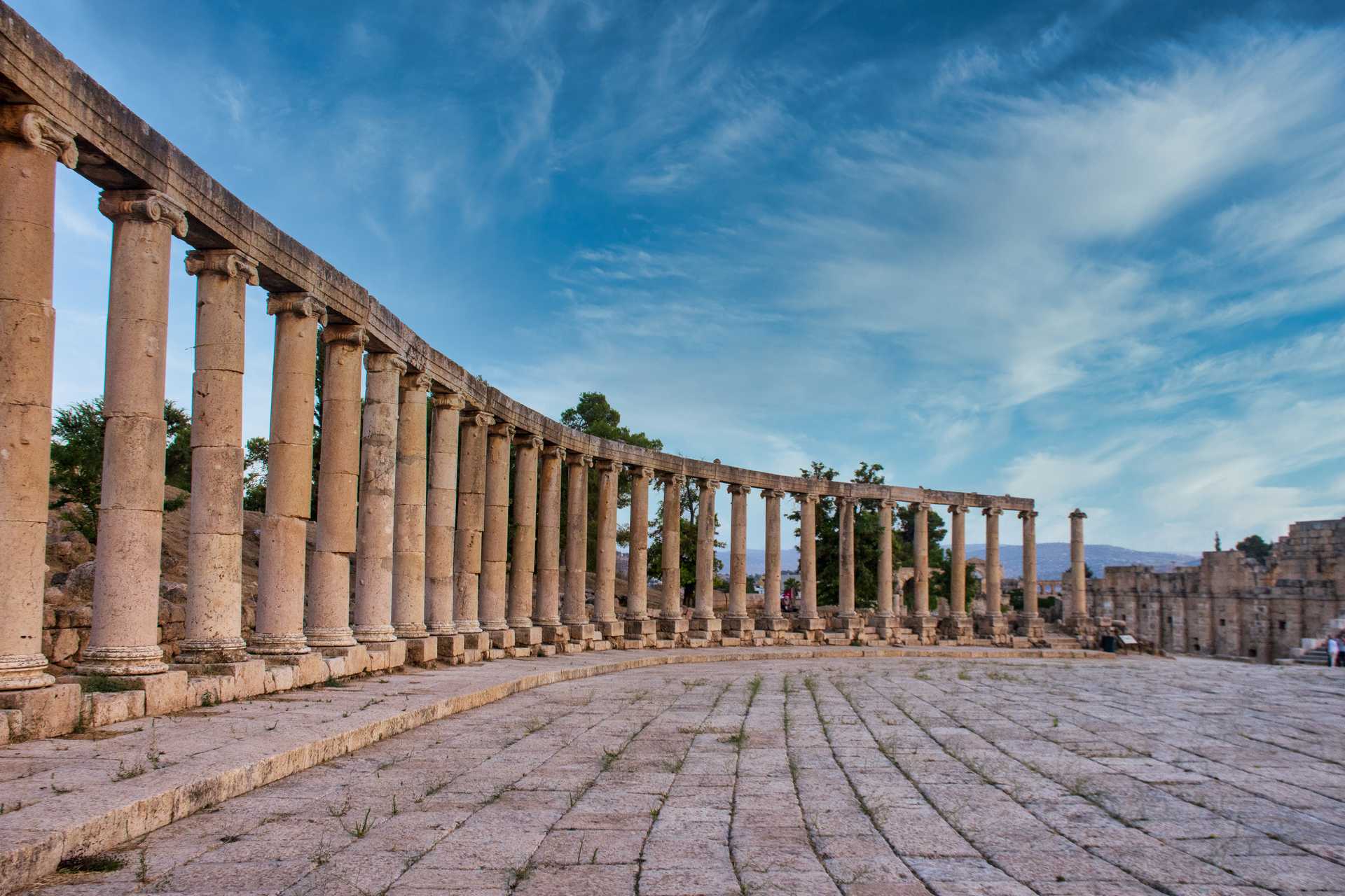 Part of an ancient building with many columns making a curve