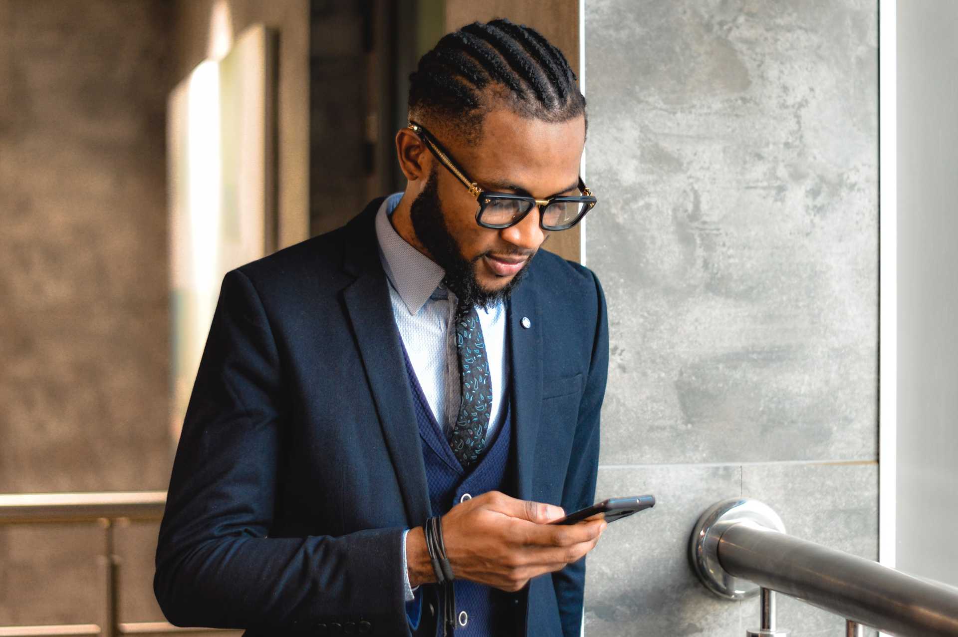 A stylish man wearing glasses on a cell phone